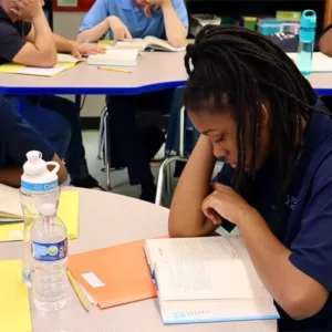 Focus Academy student reading a book during classroom discussion.