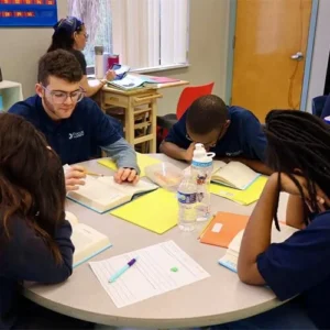 Focus Academy students reading together around a classroom table.