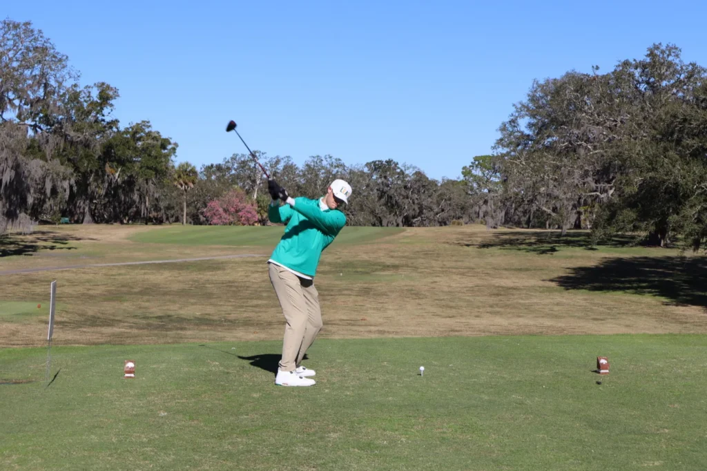 Golfer mid-swing on the fairway